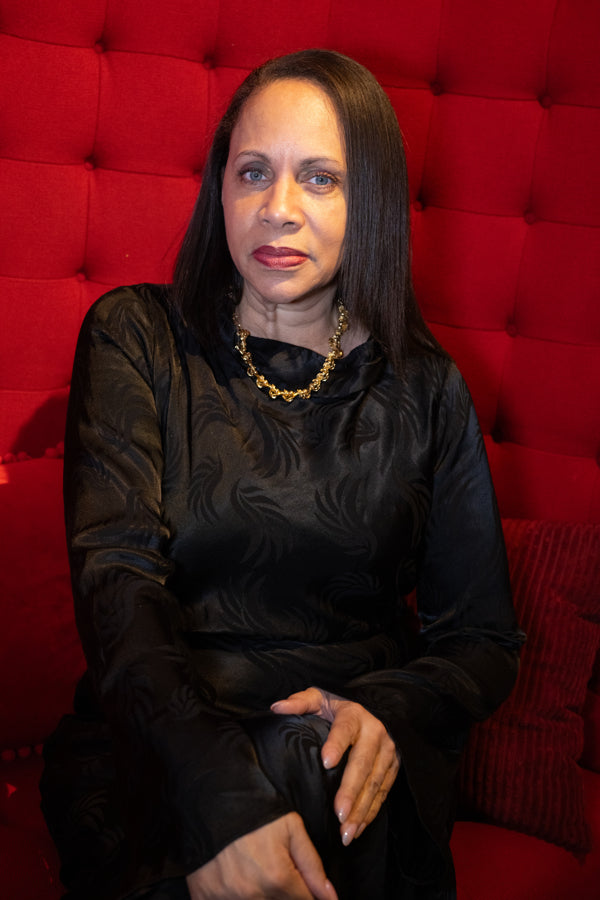 Woman in a black outfit wearing The Hands of Fate Necklace