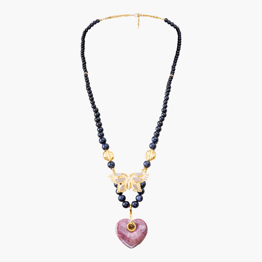Necklace with beads, gold butterfly, and pink heart pendant on a white background