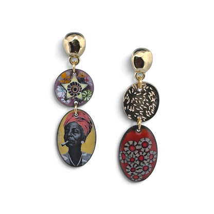 A pair of Lunaversoul Umi Says earrings with three stacked circular and oval charms on each earring. The charms feature colorful, artistic designs including a portrait, floral patterns, and textured metallic details, set against a plain white background.